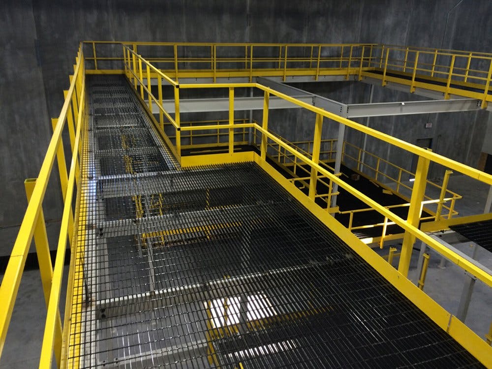 OSHA yellow steel platform better using height in manufacturing warehouse with cement walls